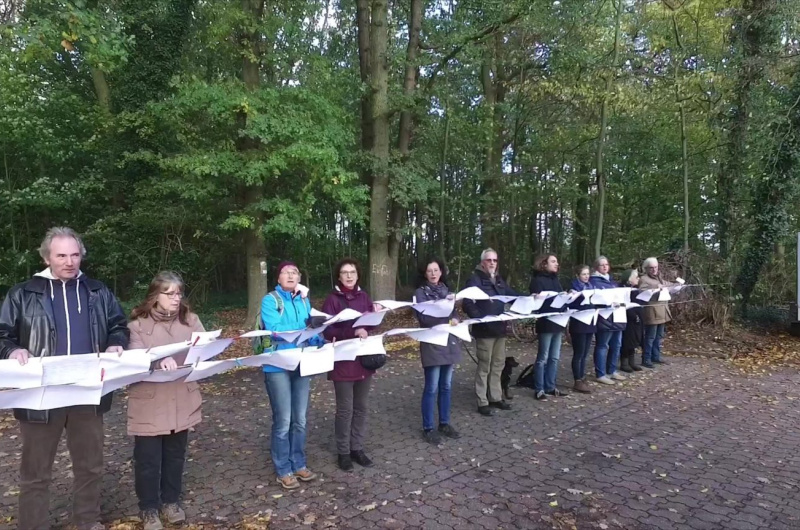 Personen im Wald mit Unterschriftenlisten